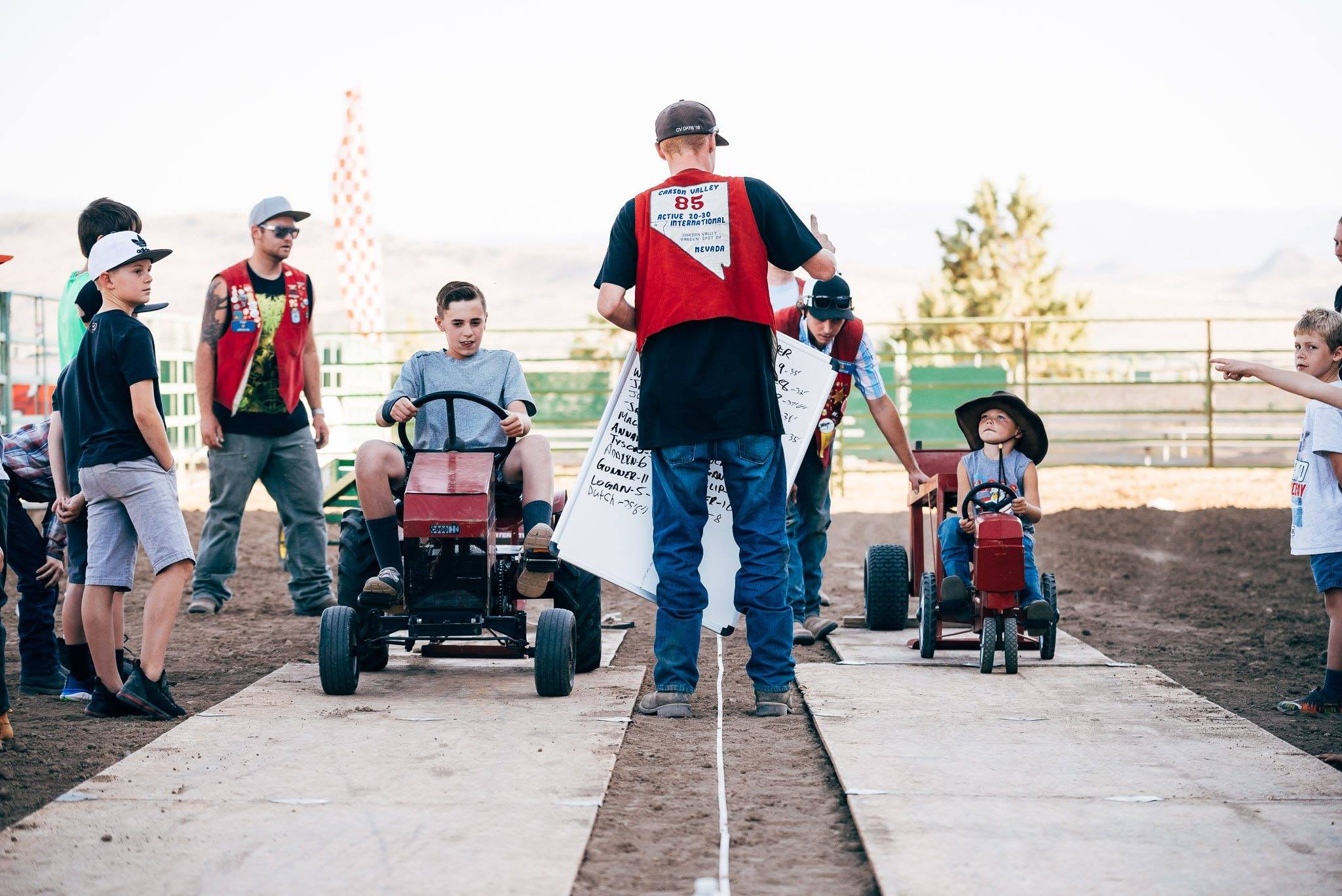 Children on pedal tractors with Carson Valley Active 20-30 volunteers